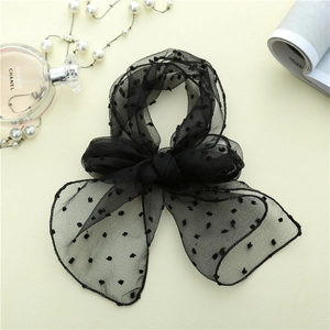 Détail du nœud papillon en tulle noir à pois avec des accessoires de mode de luxe