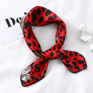 Detail of red leopard print silk scarf with floral patterns on white background
