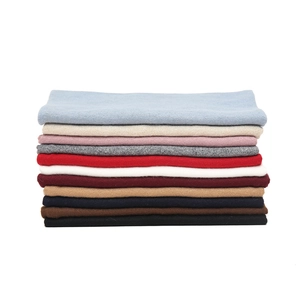 Detailed stack of knit neck warmers in eleven colors showing fine ribbed texture