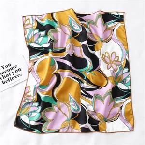 Detailed view of square silk scarf featuring abstract floral print and hand-rolled edges