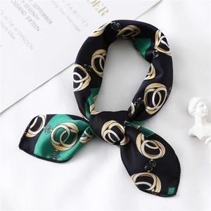 Detail of a luxury chain pattern silk scarf tied in a bow against a white background