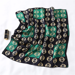 Detailed texture of green and black silk scarf with gold chain buckle patterns