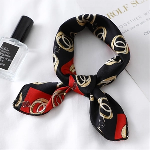 Close-up of a vintage chain print silk twilly scarf tied elegantly on white fabric