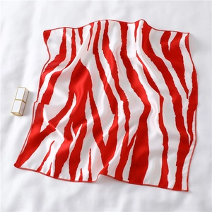 Detail of red and white animal print square silk scarf with satin finish and fine edge stitching