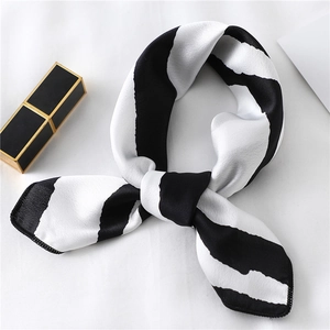 Detailed close-up of striped silk scarf with premium satin finish and rolled edges