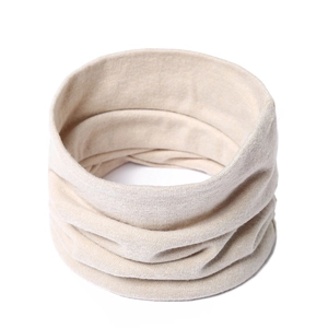 Detail of light beige knitted neck gaiter featuring soft ribbed texture and warm layers