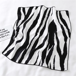 Detail of zebra pattern square scarf with smooth texture and high-contrast animal print