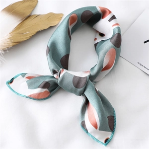 Detail of blue twilly silk scarf with cartoon cat prints and orange geometric patterns