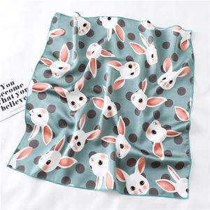 Detailed view of mint green scarf with rabbit print and dark green stitched edges