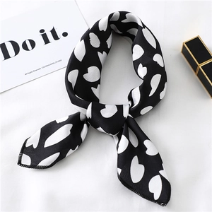 Elegant black and white heart print silk scarf styled with modern lifestyle props