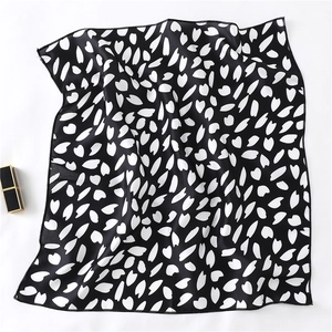 Detail of black and white cherry blossom print square scarf with neat rolled hem edges