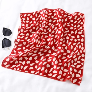 Detail of red square silk scarf with white floral print and premium hemmed edges
