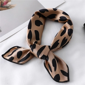 Detail of champagne satin neck scarf with black abstract print on white fabric