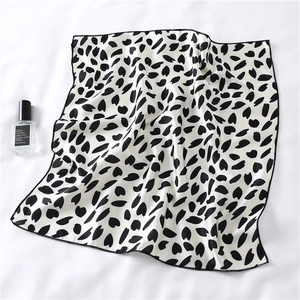 Close-up of black and white heart pattern silk scarf with delicate stitched edges