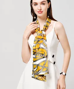 Close-up of a model wearing a mustard yellow silk scarf with vintage chain patterns