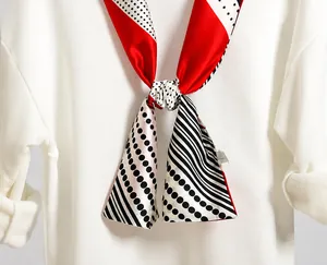 Detail of red and black geometric silk scarf styled on a white sweatshirt collar