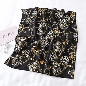 Detail of luxury silk scarf with leopard rings, golden chains and heart locks pattern