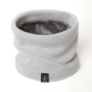 Detail of light gray knit neck warmer with thick faux fur lining and winter logo patch