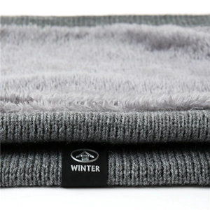 Macro detail of gray knitted neck warmer showing soft fleece lining and thick winter texture