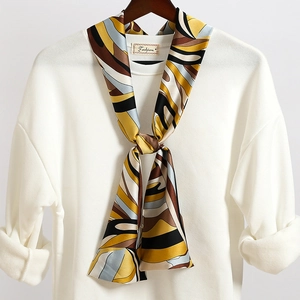 Dettaglio di un foulard in seta a motivi geometrici su colletto bianco