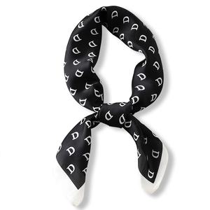 Elegant black and white silk scarf featuring alphabet D pattern tied in a stylish knot