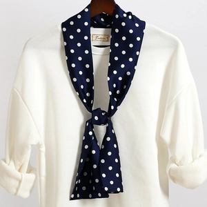Dettaglio di una sciarpa sottile blu navy a pois annodata su una felpa bianca pulita