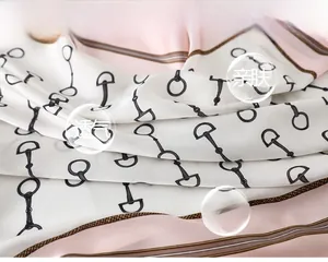 Detail of pink and beige satin silk scarf with classic horsebit chain pattern print