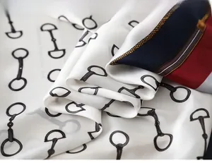 Detail of silk scarf showing horsebit pattern and multicolored striped border