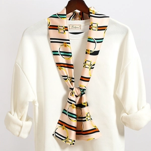 Dettaglio di un elegante foulard a righe annodato su un maglione bianco con texture