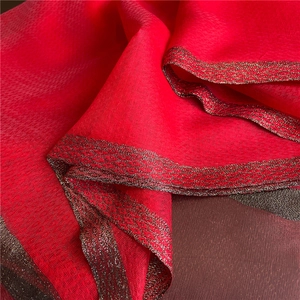 Close-up of red shawl fabric with elegant metallic gold geometric lace borders
