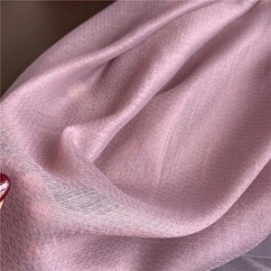 Macro detail of sheer pink silk wool scarf showing delicate texture and weave