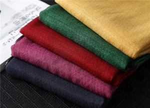Detail of stacked scarves with geometric diamond jacquard texture in various colors