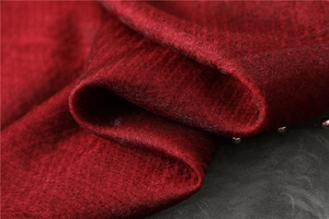 Macro detail of wine red silk scarf fabric with textured weave and silver rivet studs