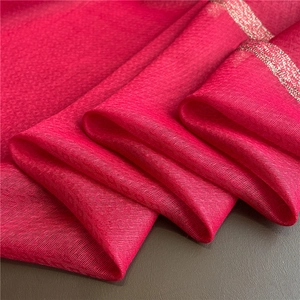 Detail of fuchsia silk wool scarf featuring fine mesh texture and glitter gold trim