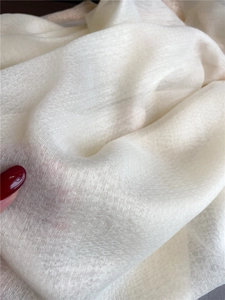 Close-up of semi-transparent silk-wool blend fabric with fine woven texture and soft drape