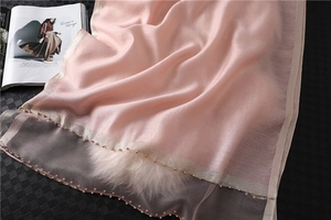 Close-up of light pink silk scarf featuring delicate beaded trim and sheer mesh edge detail