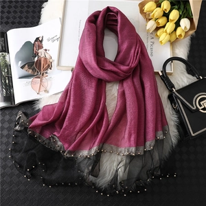 Detail of dark burgundy silk scarf with black lace border and fine golden bead accents