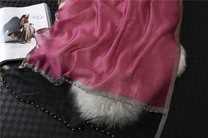 Detail of magenta silk shawl with beaded edge and gold metallic woven trim texture