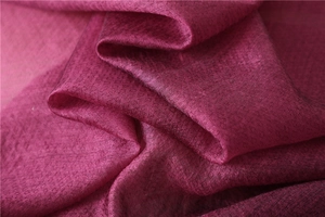 Macro shot of deep pink silk shawl showing geometric weave and glossy fabric texture