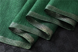 Detail of dark green jacquard scarf with fine diamond weave and silver metallic borders