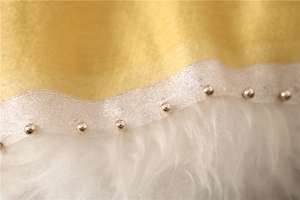Macro shot of yellow silk-wool shawl featuring silver lace trim and gold metallic beads