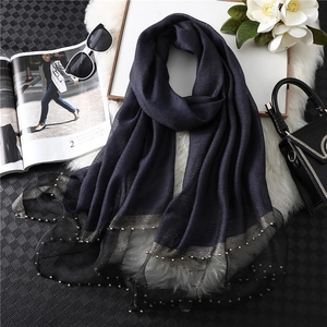 Detail of dark blue silk scarf with contrast glitter trim and elegant pearl bead embellishments