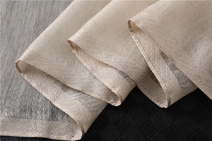 Detailed macro shot of champagne gold silk scarf fabric with shimmering metallic edges