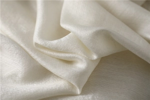 Detailed texture of ivory silk-wool scarf showing soft draping and elegant fabric sheen