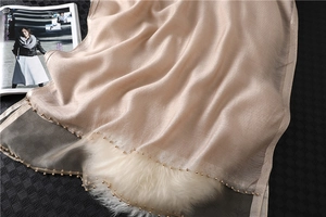 Detail of champagne silk scarf with beaded edges and elegant lustrous texture