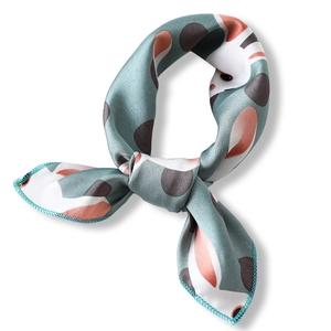 Sage green silk-like scarf with cute cartoon animal print tied in a neat knot