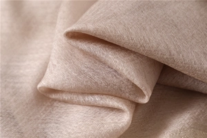 Macro view of light champagne silk scarf showing fine weave texture and subtle luster