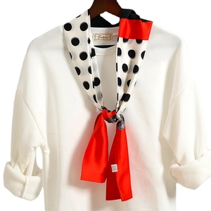 Sciarpa sottile a pois con punta rossa abbinata a un maglione di maglia bianco