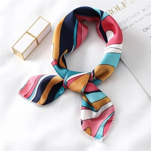 Detail van elegante satijnen twilly sjaal met geometrische prints en fijne witte stiksels
