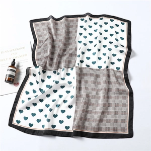 Detail of silk square scarf featuring heart pattern and houndstooth check with black border